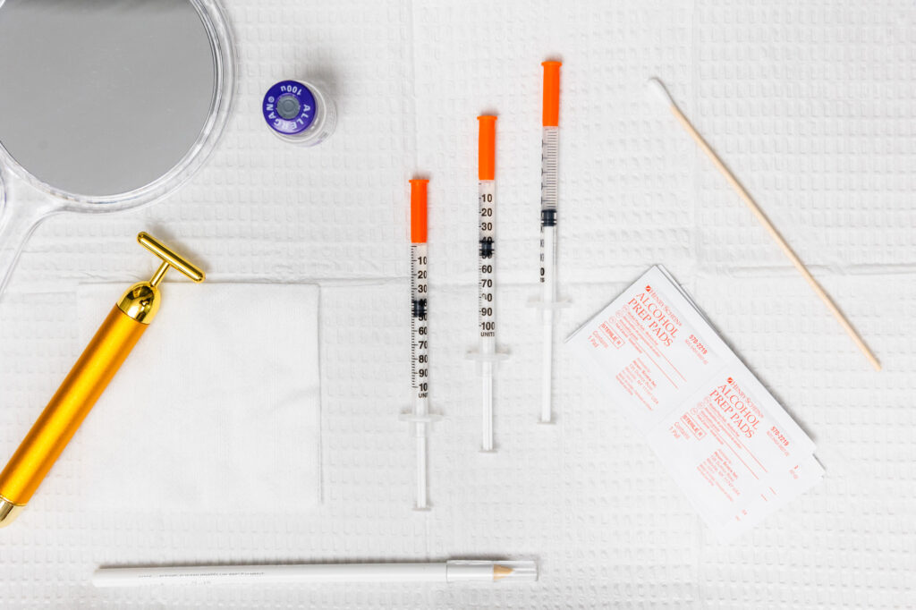 A layout of injection tools on a treatment table at Clarity Health & Aesthetics as a provider prepares to administer lip fillers near Kansas City.