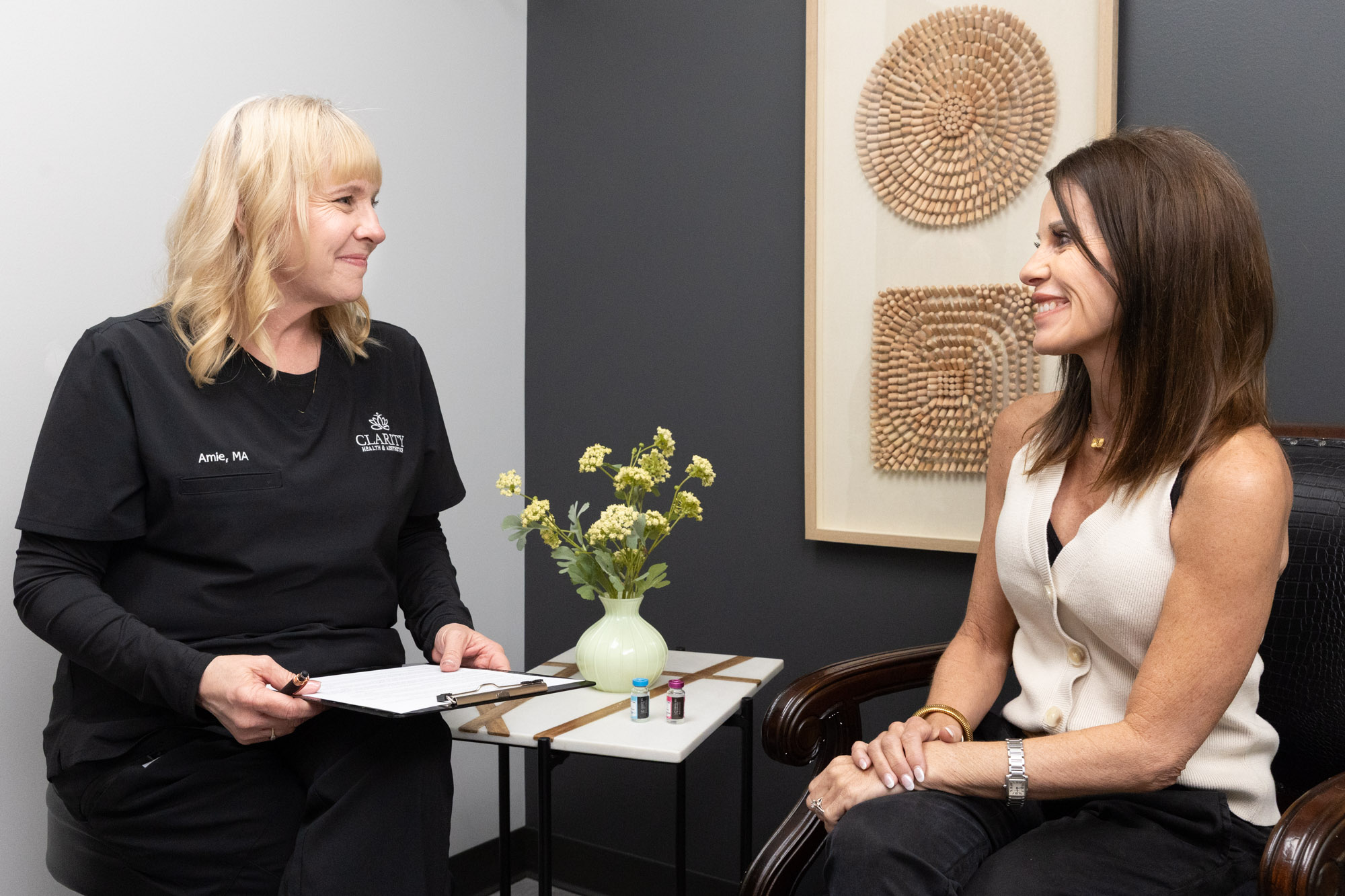 A provider at Clarity Health & Aesthetics talking with a patient about using masseter Botox near Parkville, MO, to end her jaw pain.